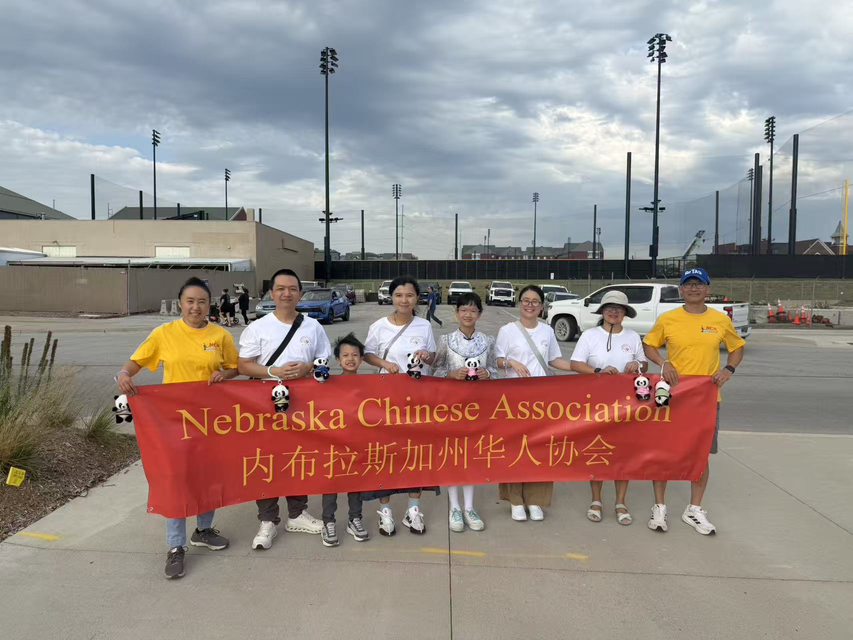 NCA participants holding the association banner and panda mascots outdoors