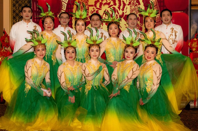 NCA dancers in green and gold costumes pose together