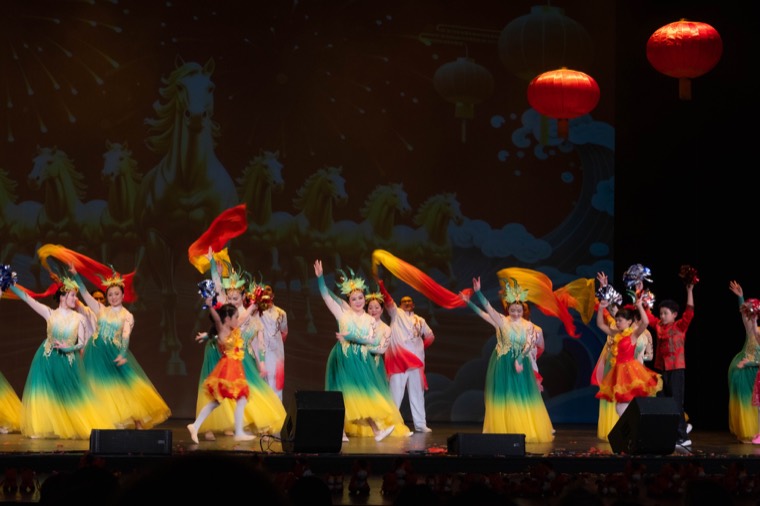 Performers dance beneath red lanterns on the New Year stage